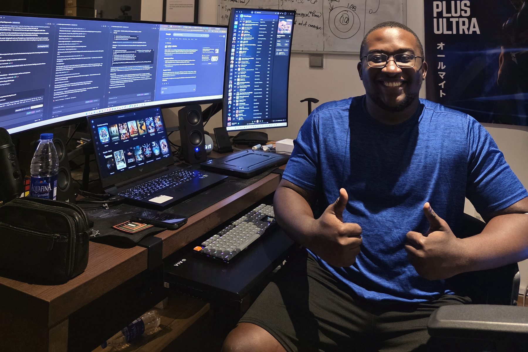 Joshua at his desk setup with monitors and a mechanical keyboard